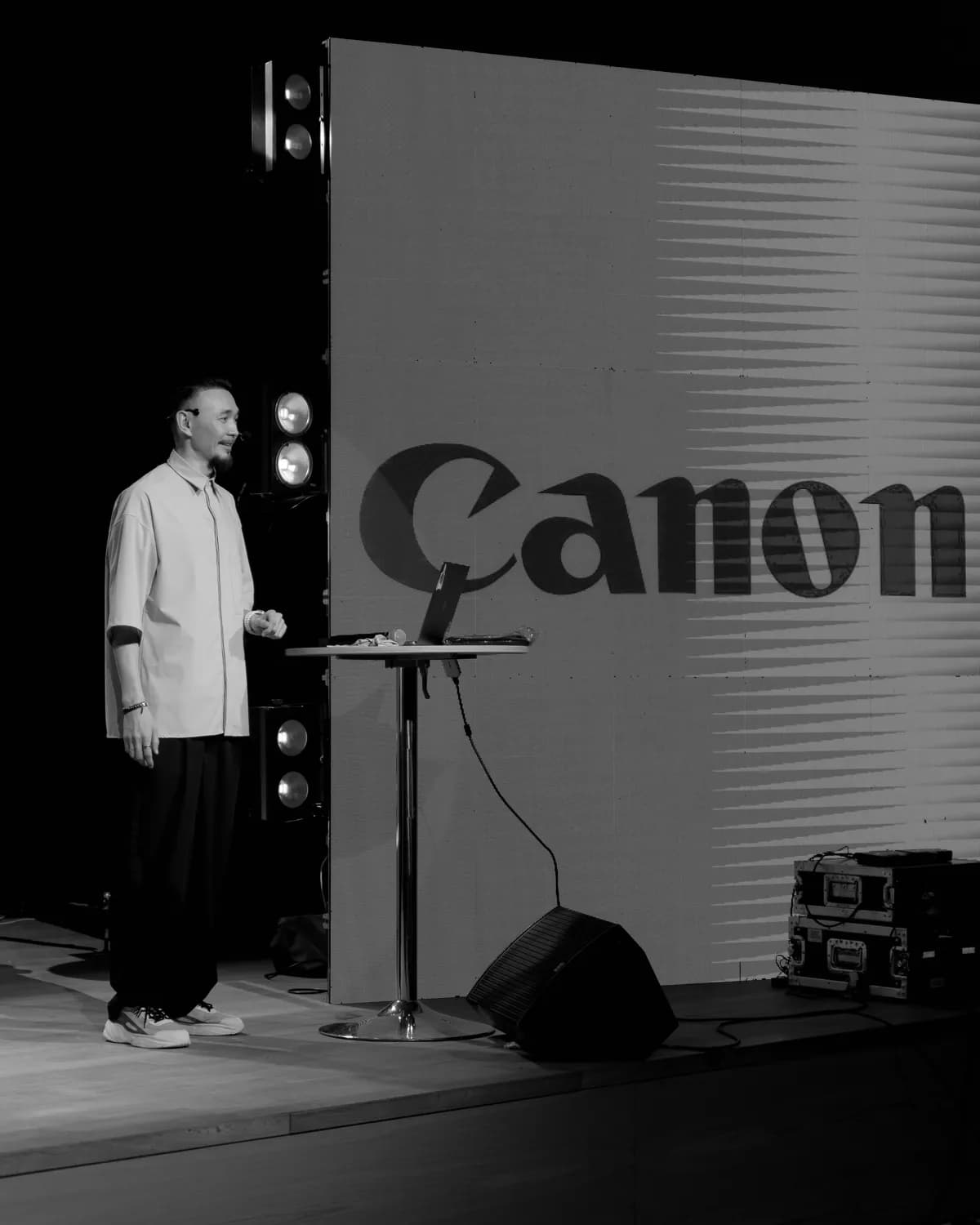 Аскар Бумага выступает на сцене перед экраном Canon